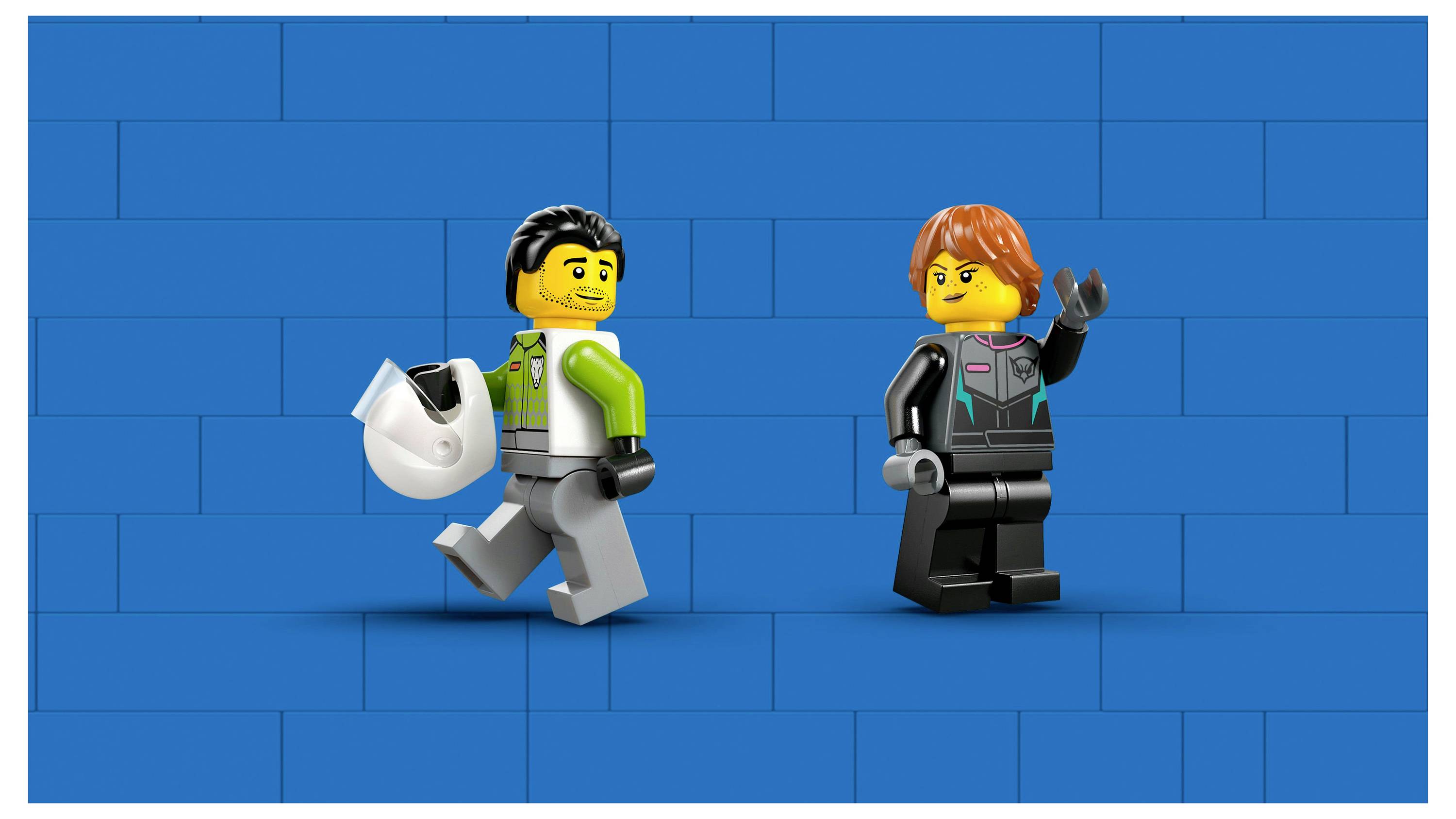 Two LEGO figures on a blue brick background: one holds a helmet and walks cheerfully; the other waves, dressed in matching attire.