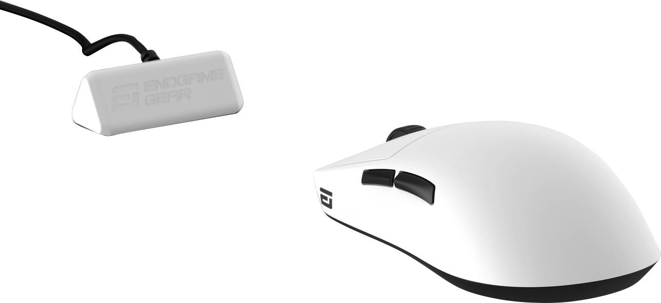 A white gaming mouse with two side buttons and a black bottom, branded with 'ENDGAME GEAR'. It is connected to a rectangular USB receiver.