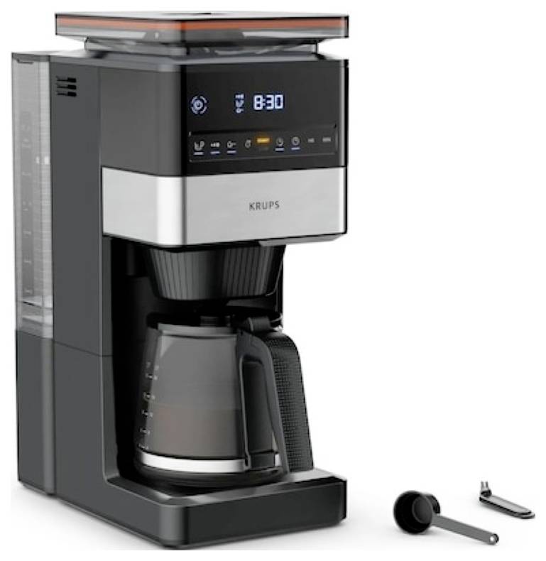 A sleek coffee maker with digital display showing '8:30'. Includes a carafe, filter, scoop, and cleaning tool. Brand 'KRUPS' visible.