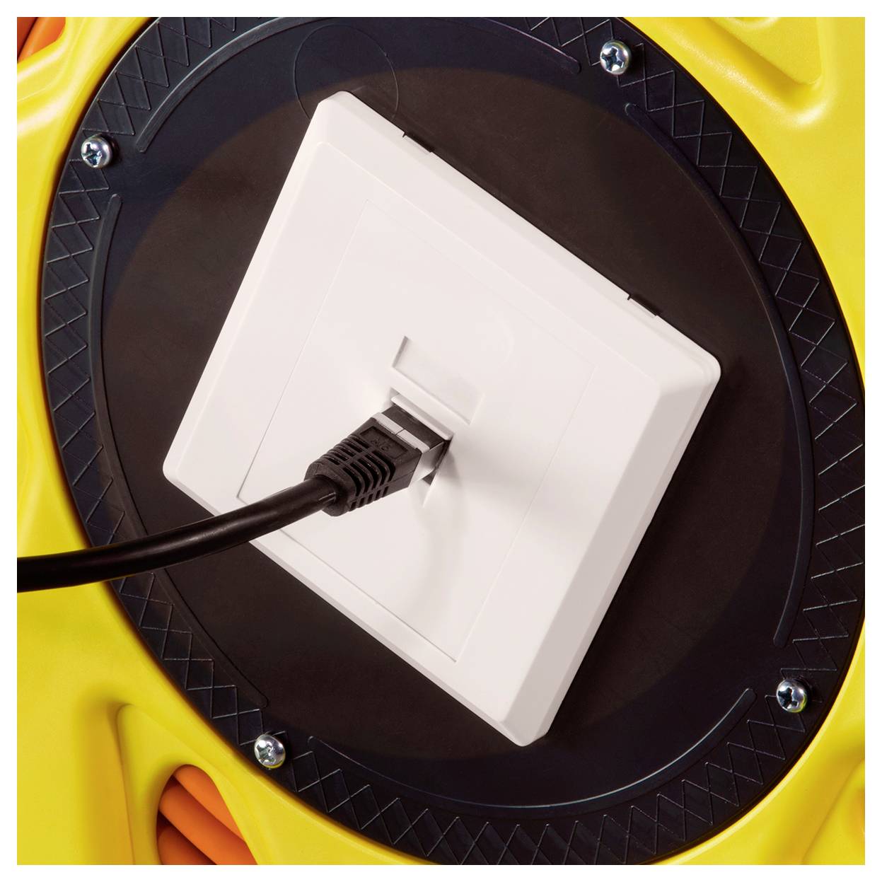A close-up of a white network socket with a black ethernet cable plugged in, mounted on a yellow and black surface.