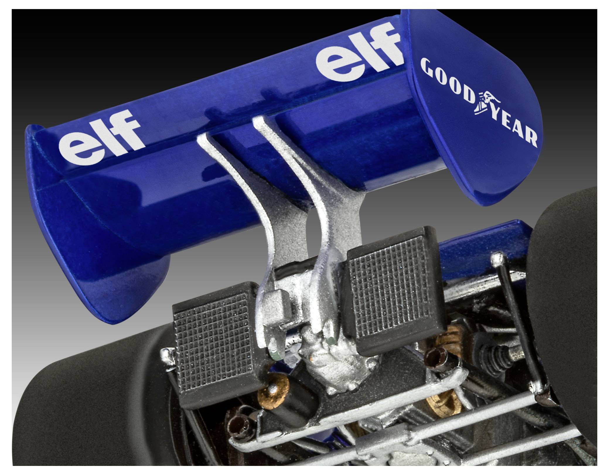 Rear wing and suspension components of a vintage race car. Blue wing with 'elf' and 'Goodyear' logos, intricate mechanical details visible.