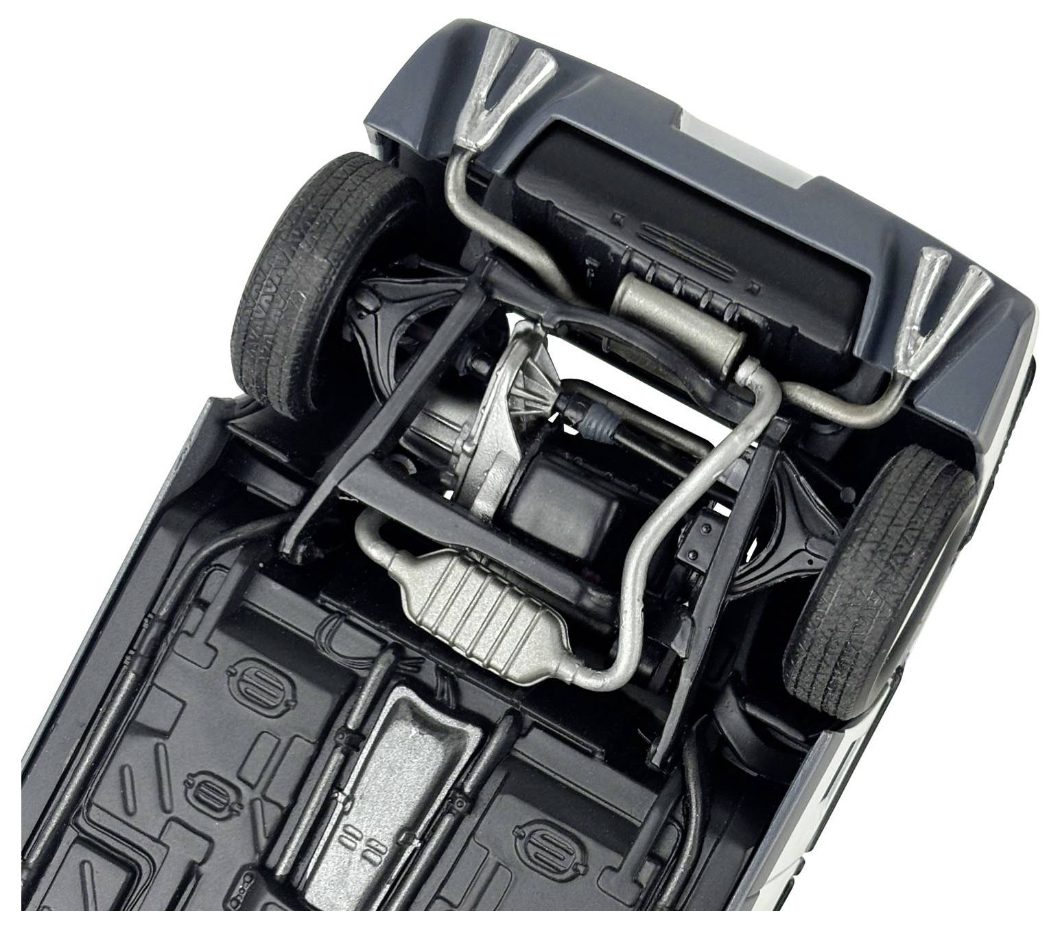 The underside of a car showing detailed view of the exhaust system, suspension, and tires, highlighting automotive parts arrangement.