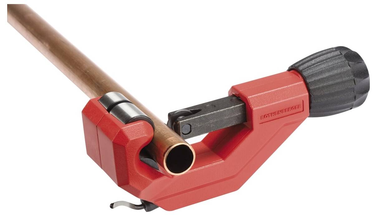 A pipe cutter with a red handle is clamped onto a copper pipe, demonstrating its intended use for cutting pipes.