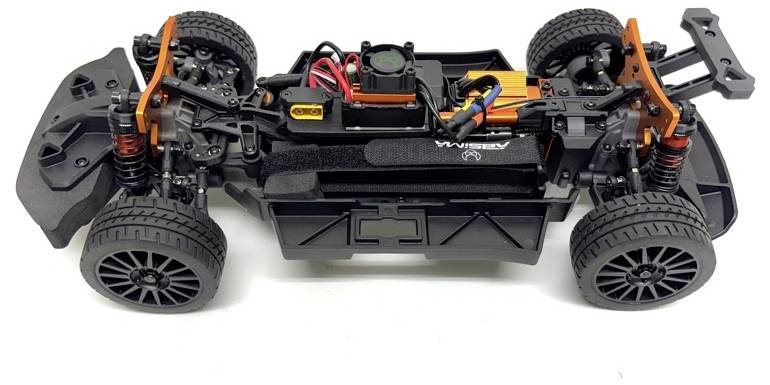 A toy car chassis with detailed components, including wheels, suspension, wires, and battery compartment, seen from above.