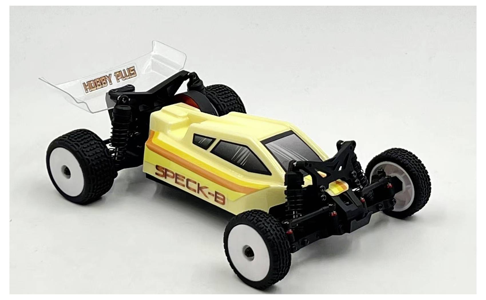 A yellow and white remote-controlled race car with black wheels and red stripe details, labeled 'SPECK-B' and 'HOBBY PLUS' on the spoiler.