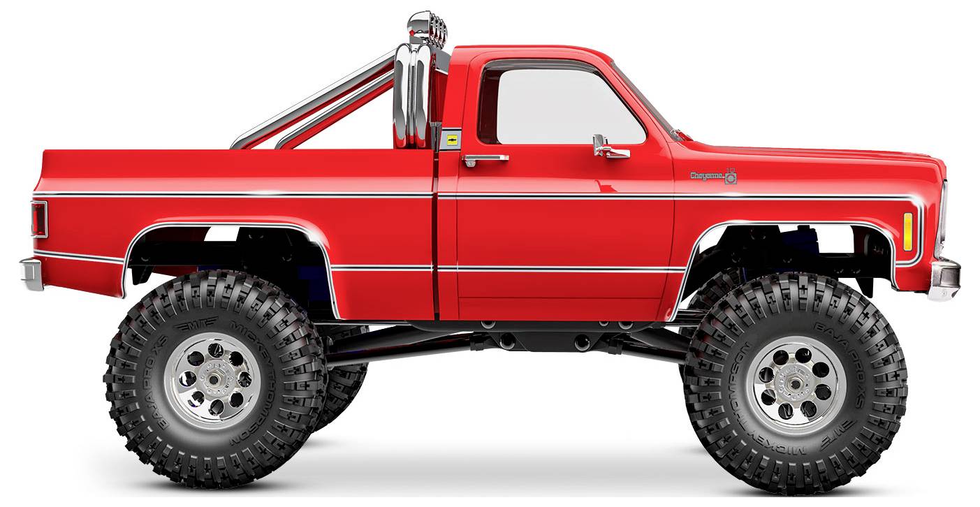 A bright red lifted pickup truck with oversized tires and chrome detailing on the side and exhaust pipes.