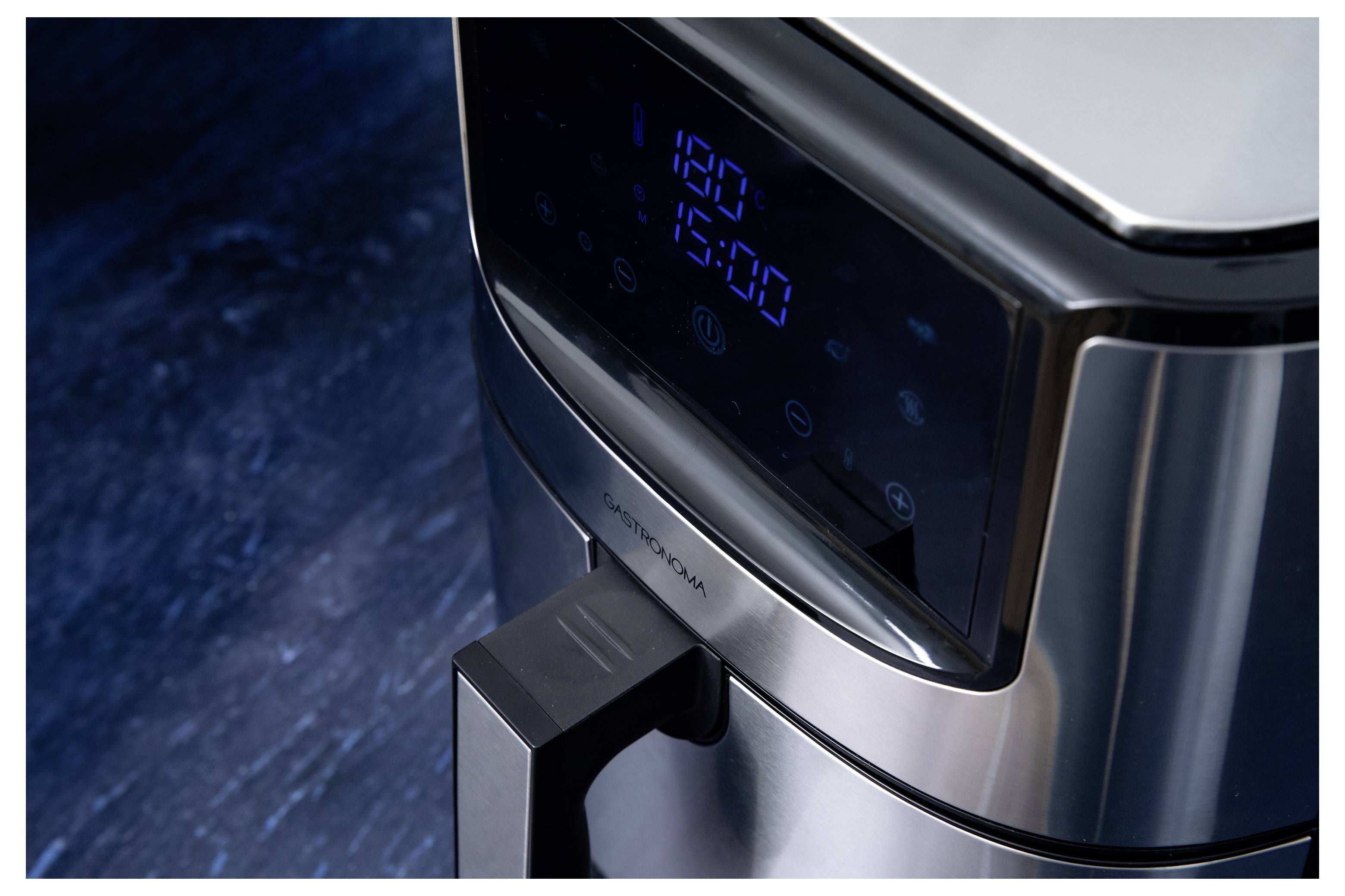 A digital display shows '180°C' and '15:00' on a sleek, metallic air fryer set against a dark surface, indicating cooking settings.