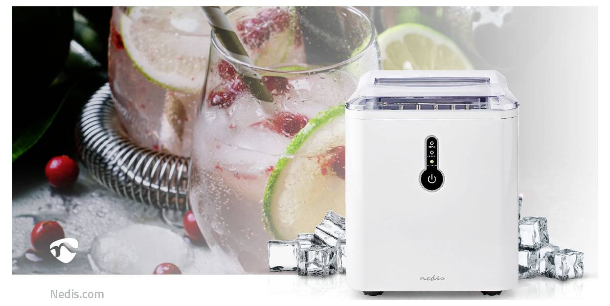 A white countertop ice maker next to a tumbler with slices of lime, strawberries, and mint leaves, surrounded by ice cubes.