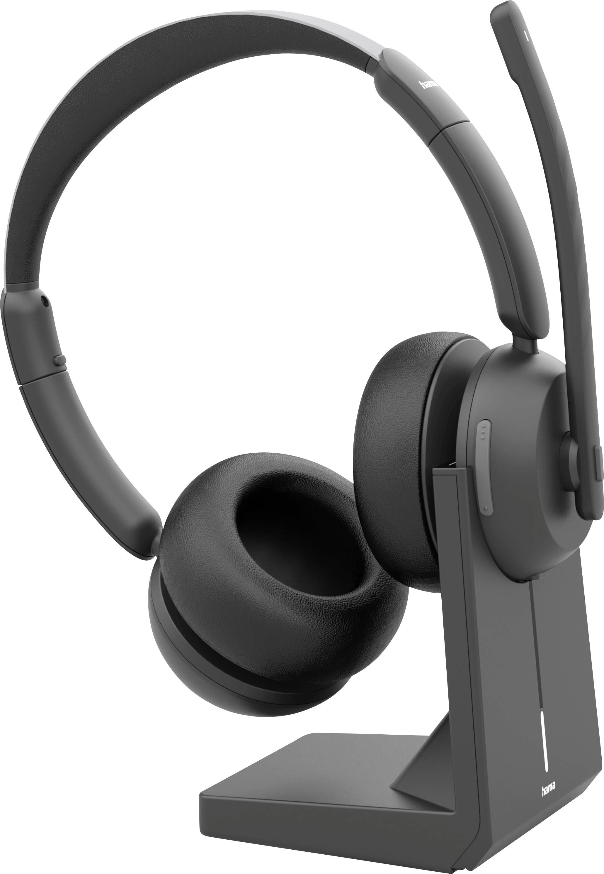 A black wireless headset with a microphone is placed on a charging stand. The headset features padded ear cups and a flexible microphone boom.
