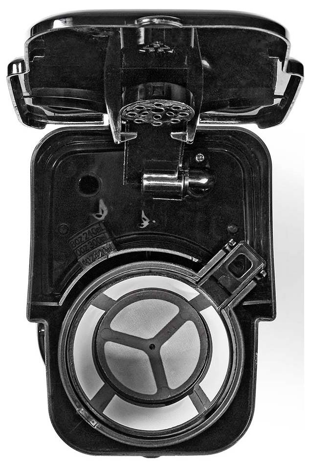 'Top view of a black plastic electrical device's open casing, showing inner components and a circular wheel-like structure.'