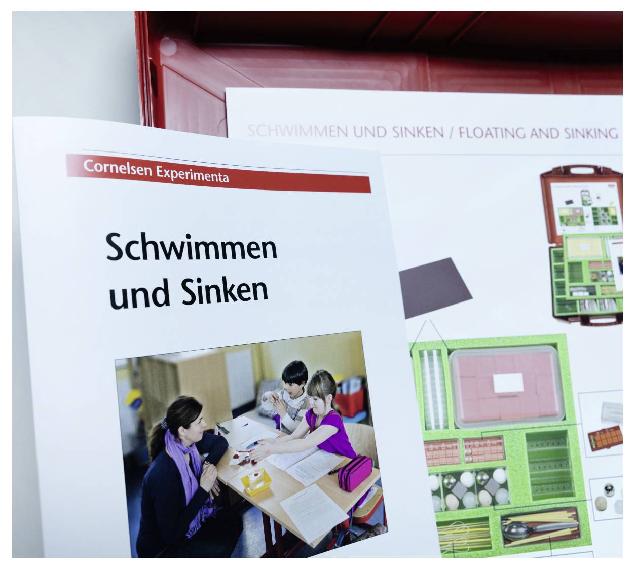 'A booklet titled 'Schwimmen und Sinken' with an image of a teacher and children engaged in an educational activity.'