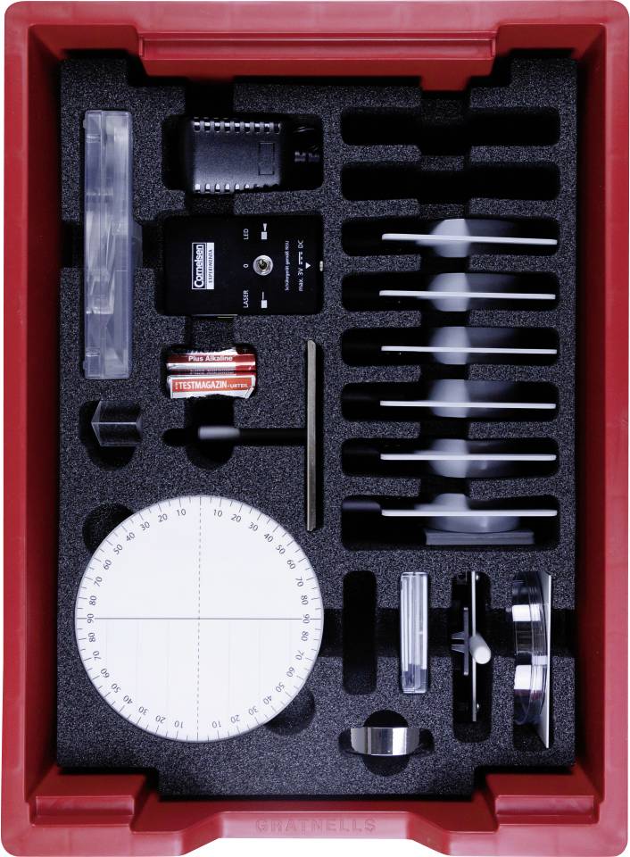 Physics experiment kit in a red container, featuring a model turntable, battery, spool, ruler, and various small electronic components.