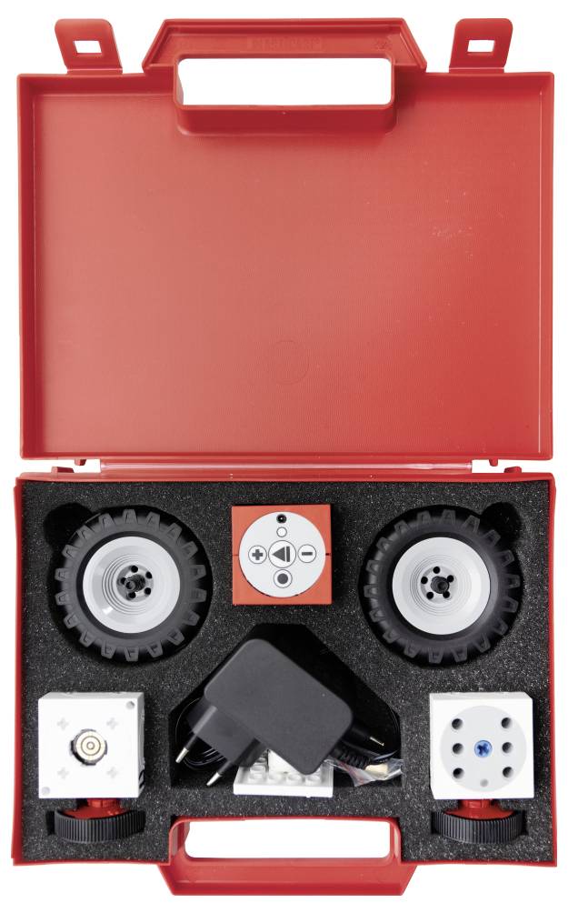 Robotics kit in a red case containing wheels, motors, and a power adapter, organized within a foam insert.