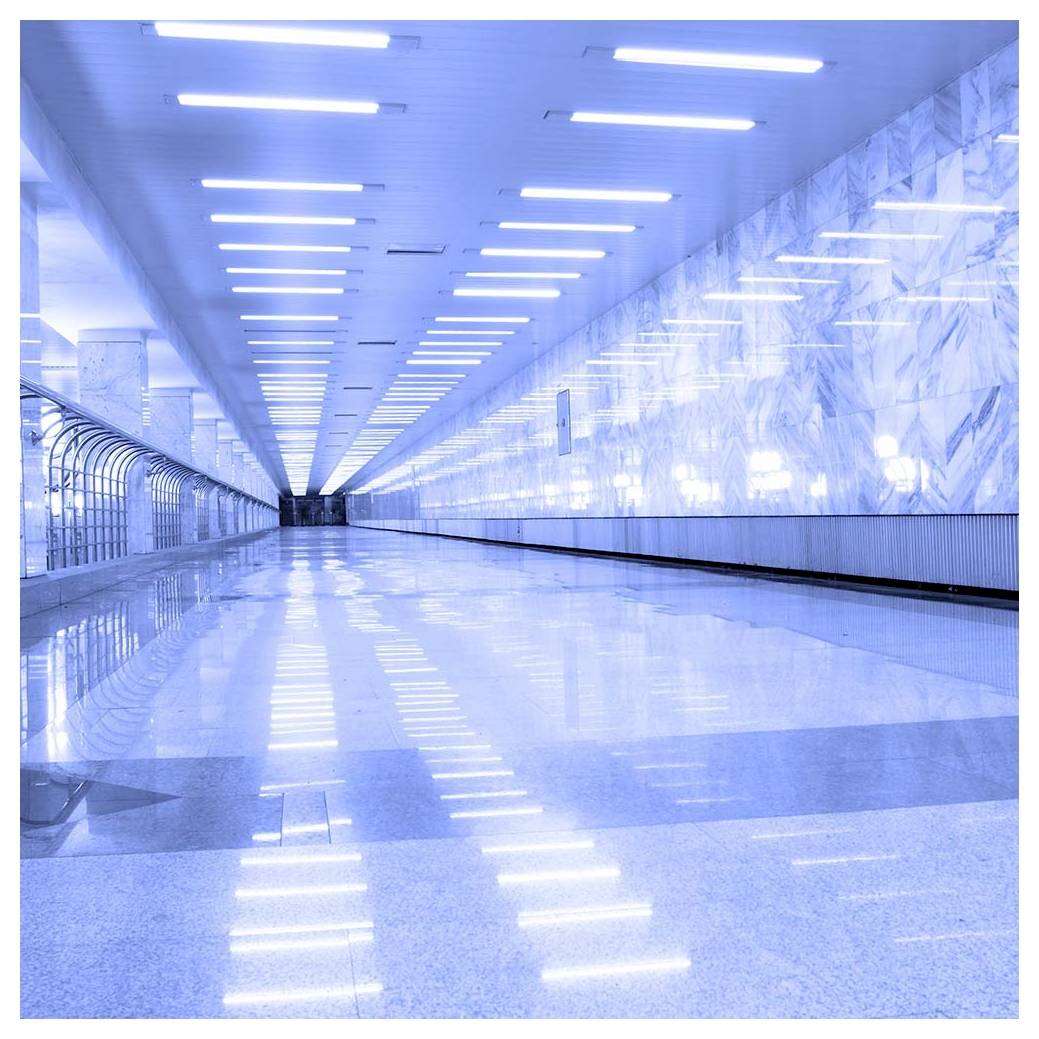 An empty, polished underground tunnel with bright lights on the ceiling and reflective marble walls, creating an expansive, modern ambiance.