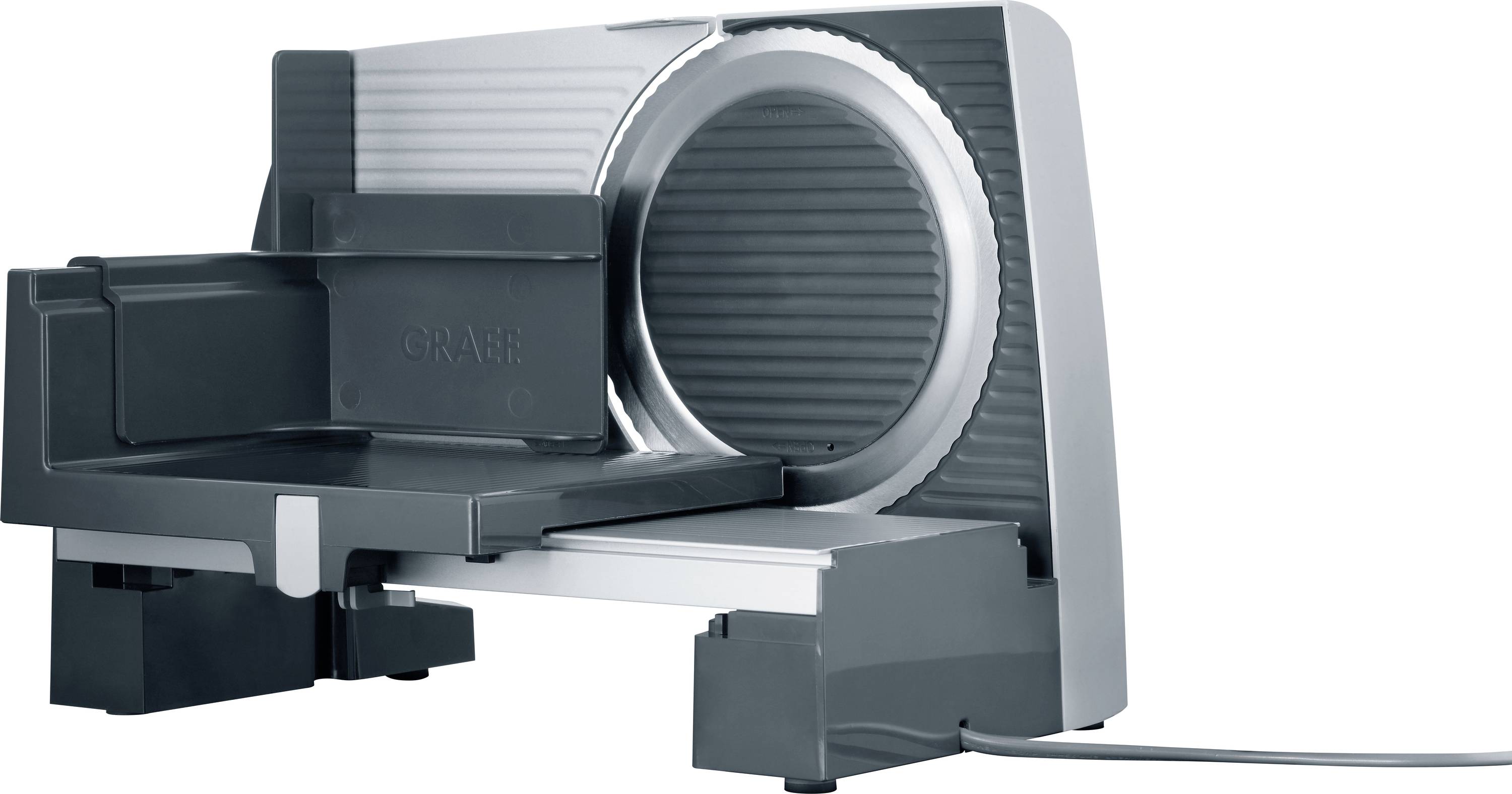 A metal meat slicer with a large circular blade and a sliding tray for food placement. The slicer is powered, with a power cord attached.
