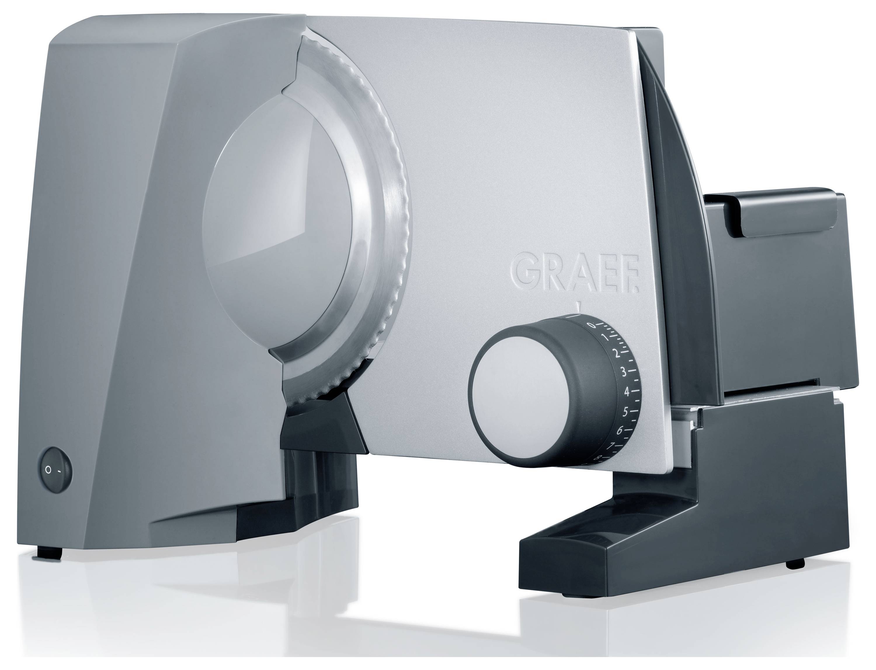 A silver and black electric meat slicer with a circular blade and adjustable thickness dial, positioned on a reflective surface.