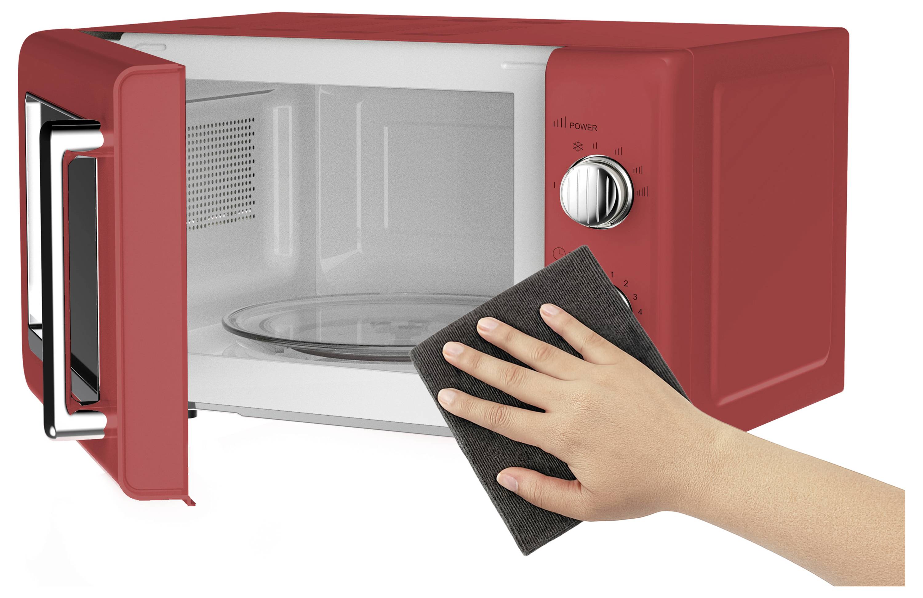 A red microwave with an open door. A hand is cleaning the interior with a dark cloth.