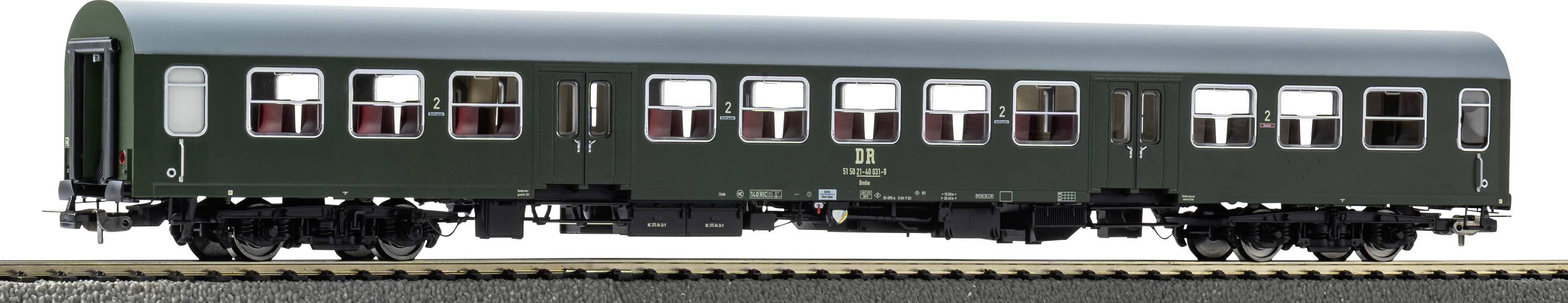 A model of a vintage green passenger train carriage on a display track, featuring detailed windows and doors, showcasing classic design.