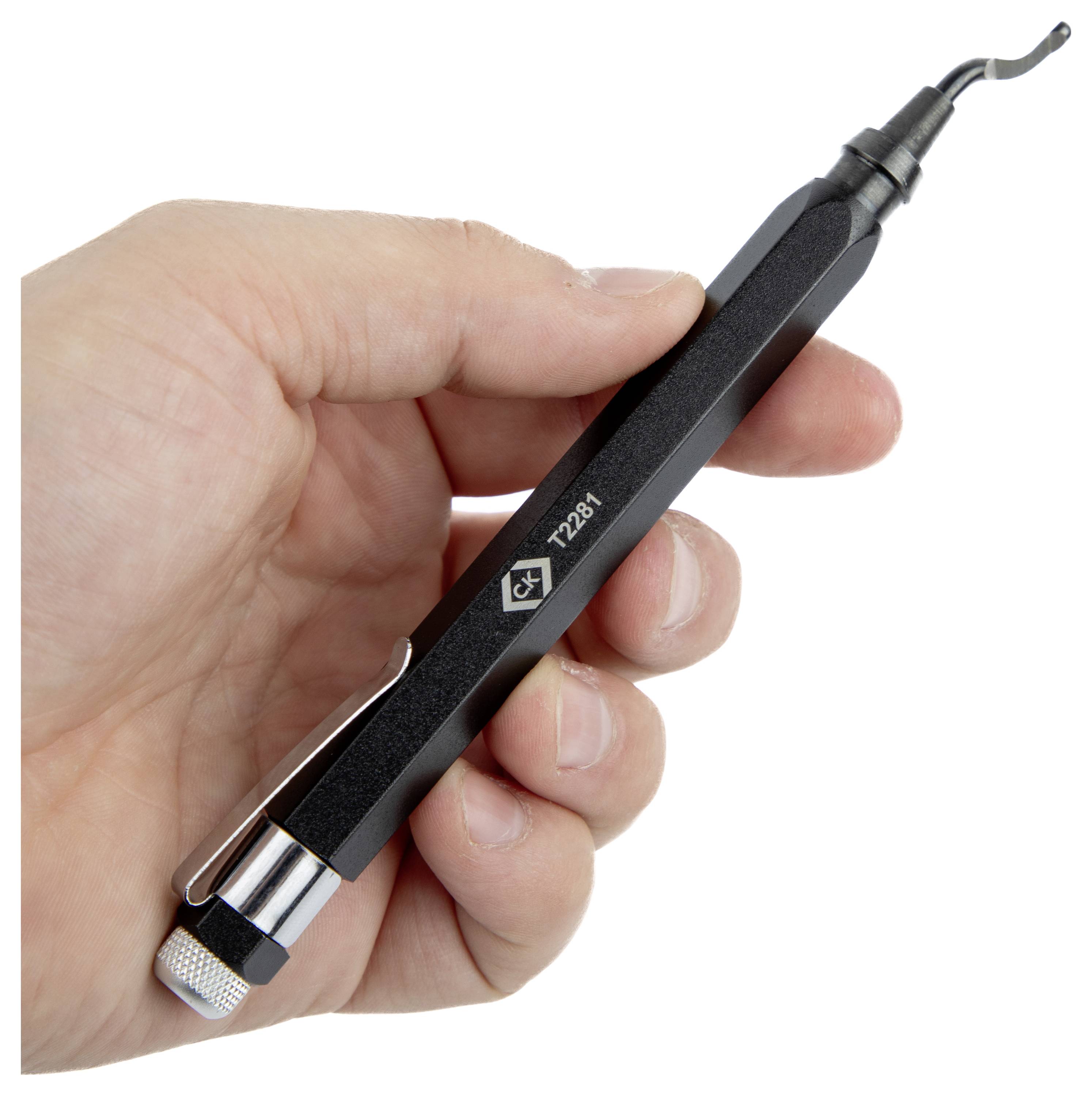 A hand holding a black precision tool with a curved tip, marked 'T2081'. The tool is cylindrical with a metal clip near one end.