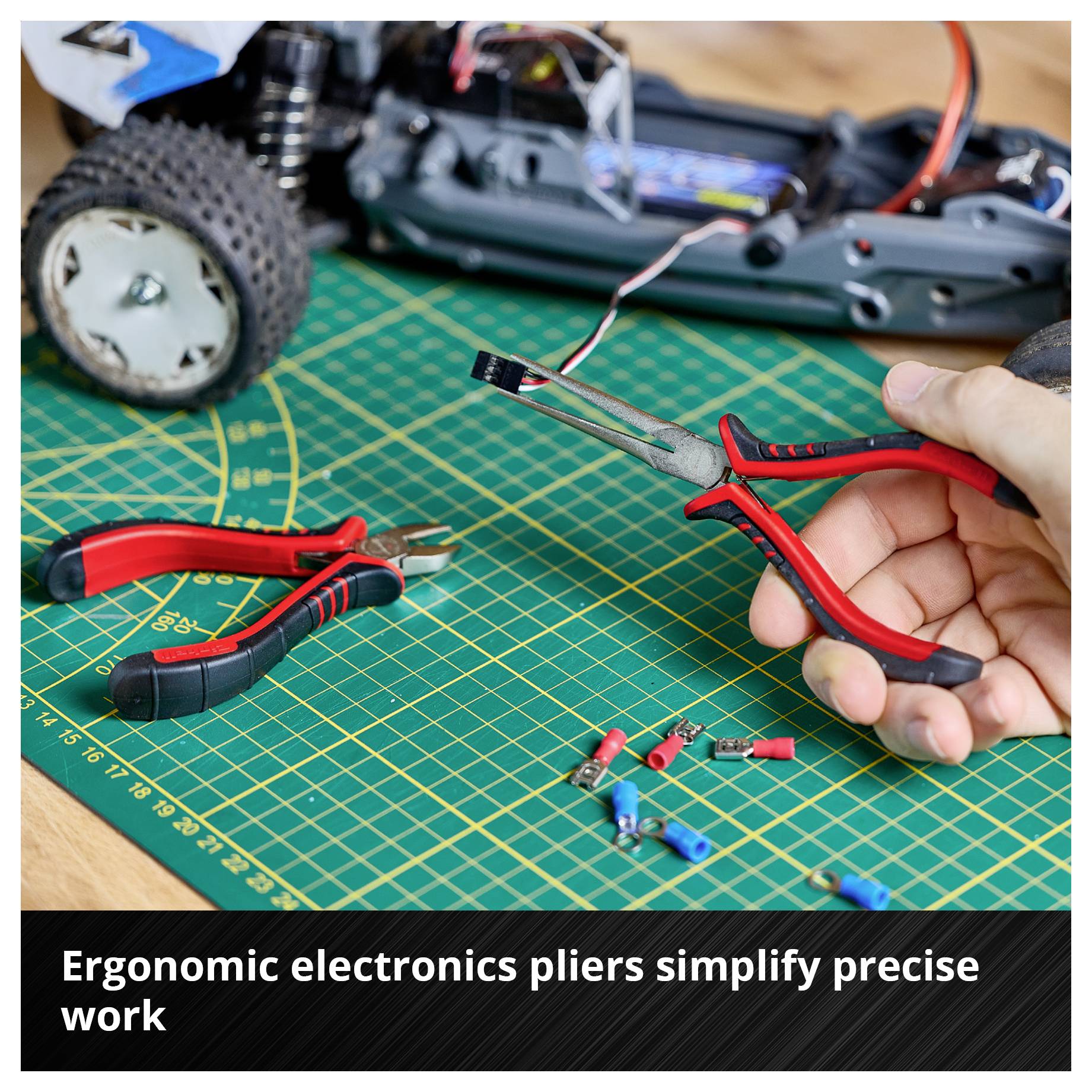 Workbench with model car, electrician's pliers and cables. Caption: 'Ergonomic electrician's pliers make precise work easier'.