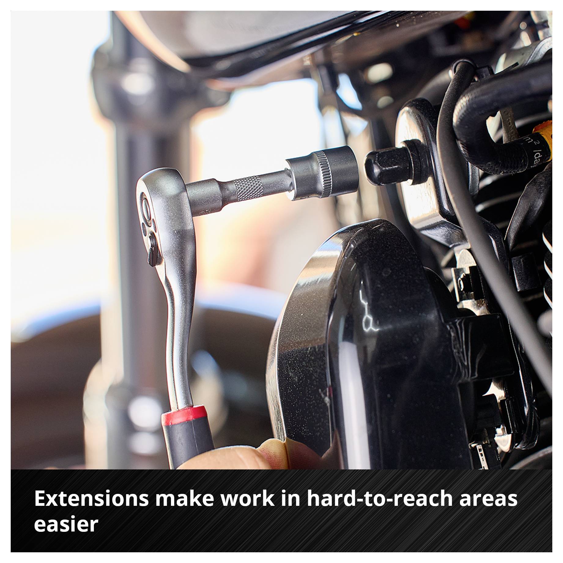 Eine Ratsche mit Verlängerung wird an einem schwer erreichbaren Teil eines Motors verwendet. Text: 'Verlängerungen erleichtern das Arbeiten an schwer erreichbaren Stellen'.
