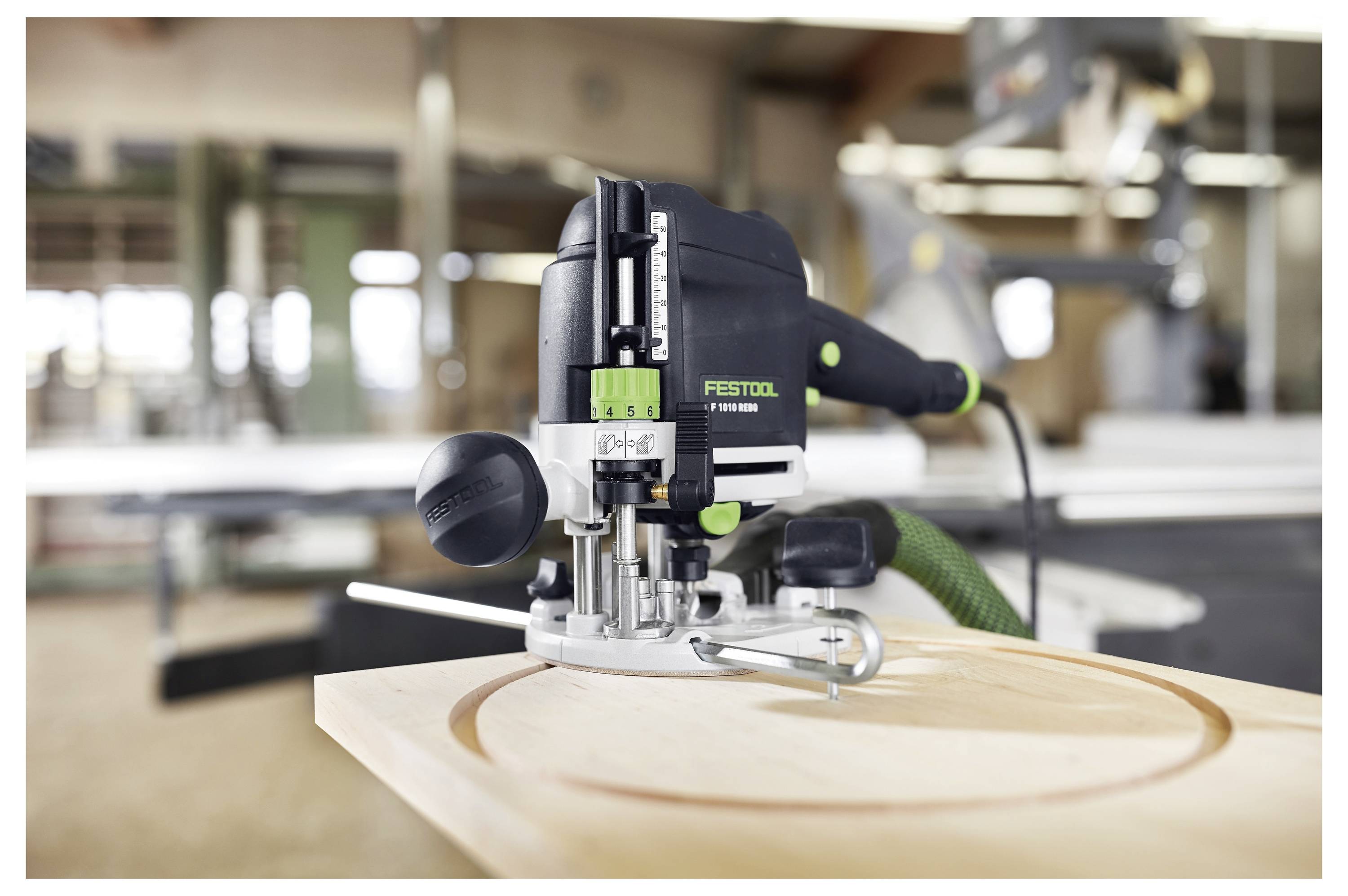 A woodworking tool is carving a circular design into a wooden surface in a workshop setting, emphasizing precision and craftsmanship.