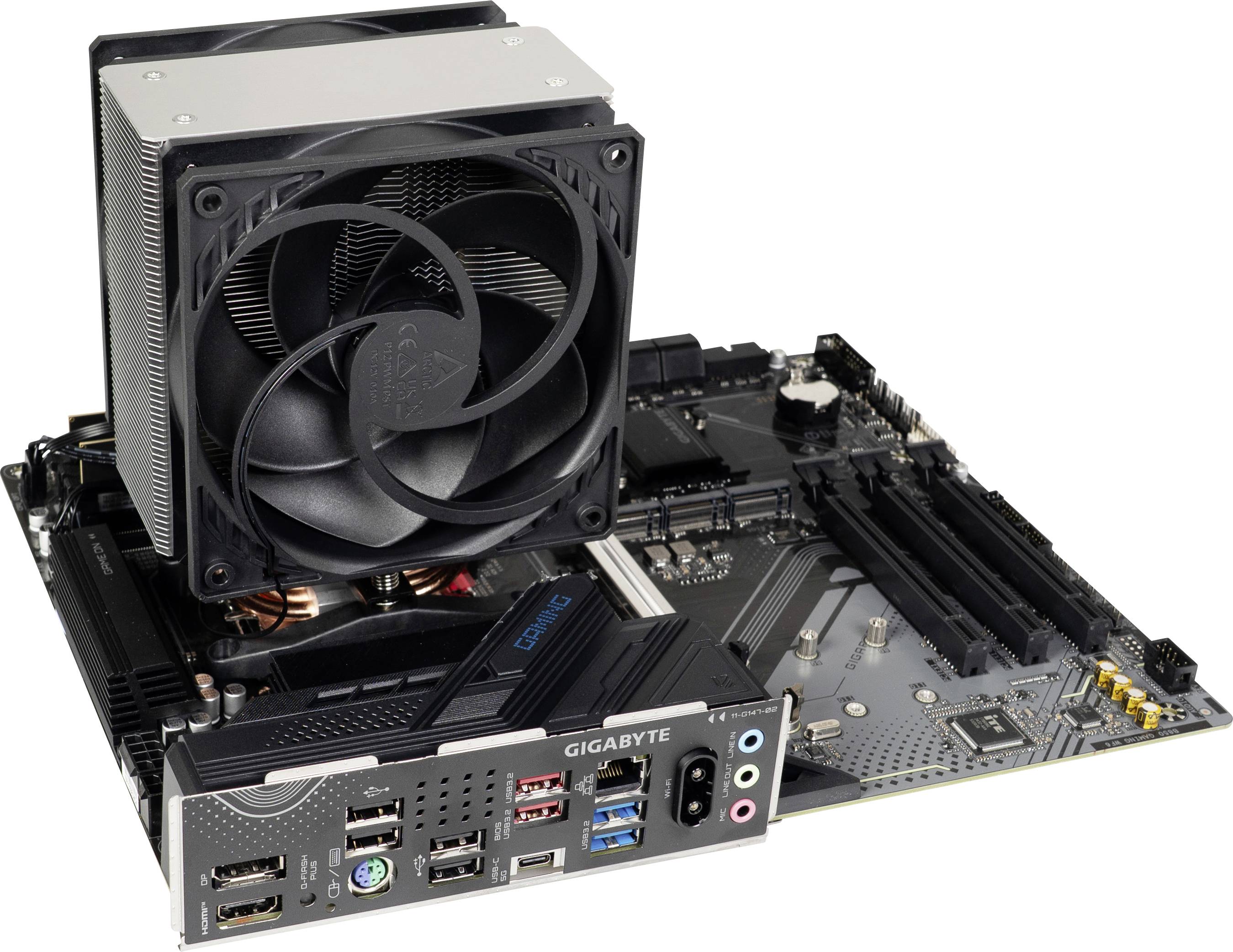 A computer motherboard with mounted CPU cooler, featuring multiple ports and expansion slots, branded 'Gigabyte' on the side panel.