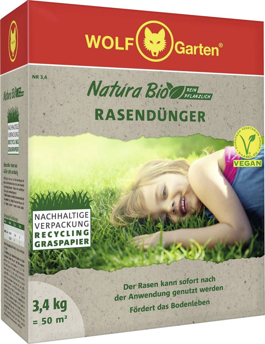 A child lying on grass, smiling. The packaging of WOLF-Garten Natura Bio organic lawn fertilizer indicates it's vegan and eco-friendly.