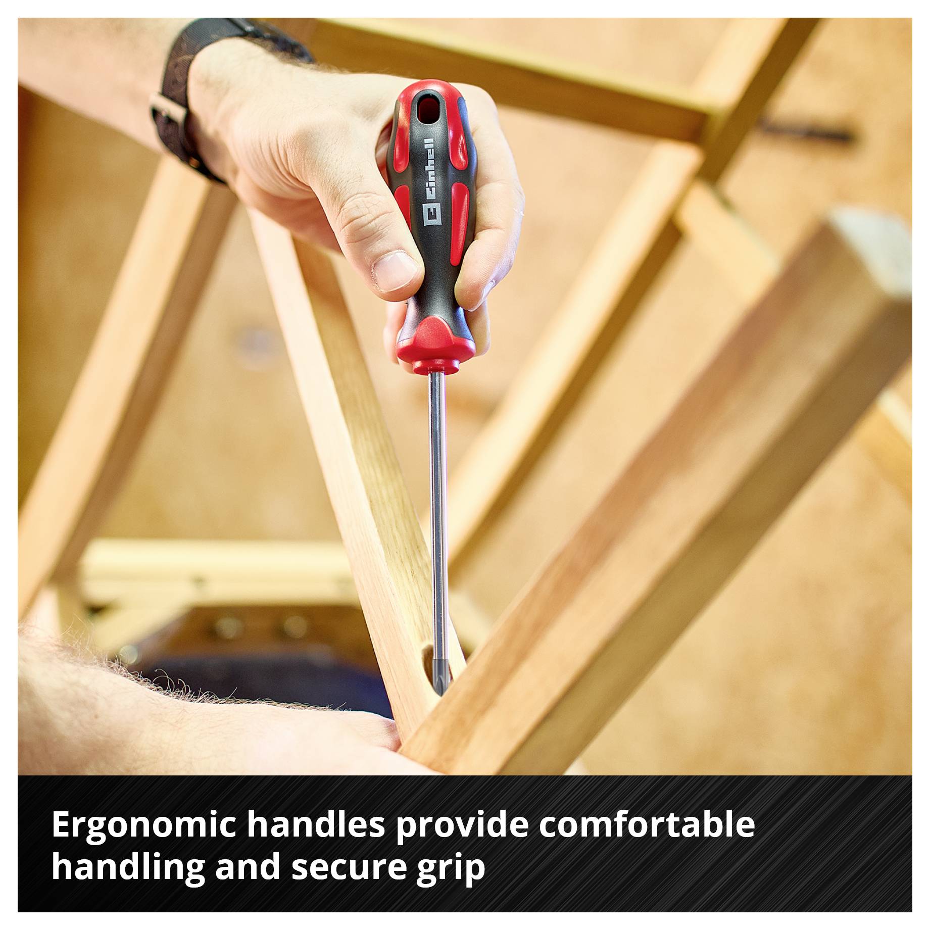 A hand with a screwdriver working on a wooden frame; at the bottom it says: 'Ergonomic grips offer comfortable handling and secure grip'.