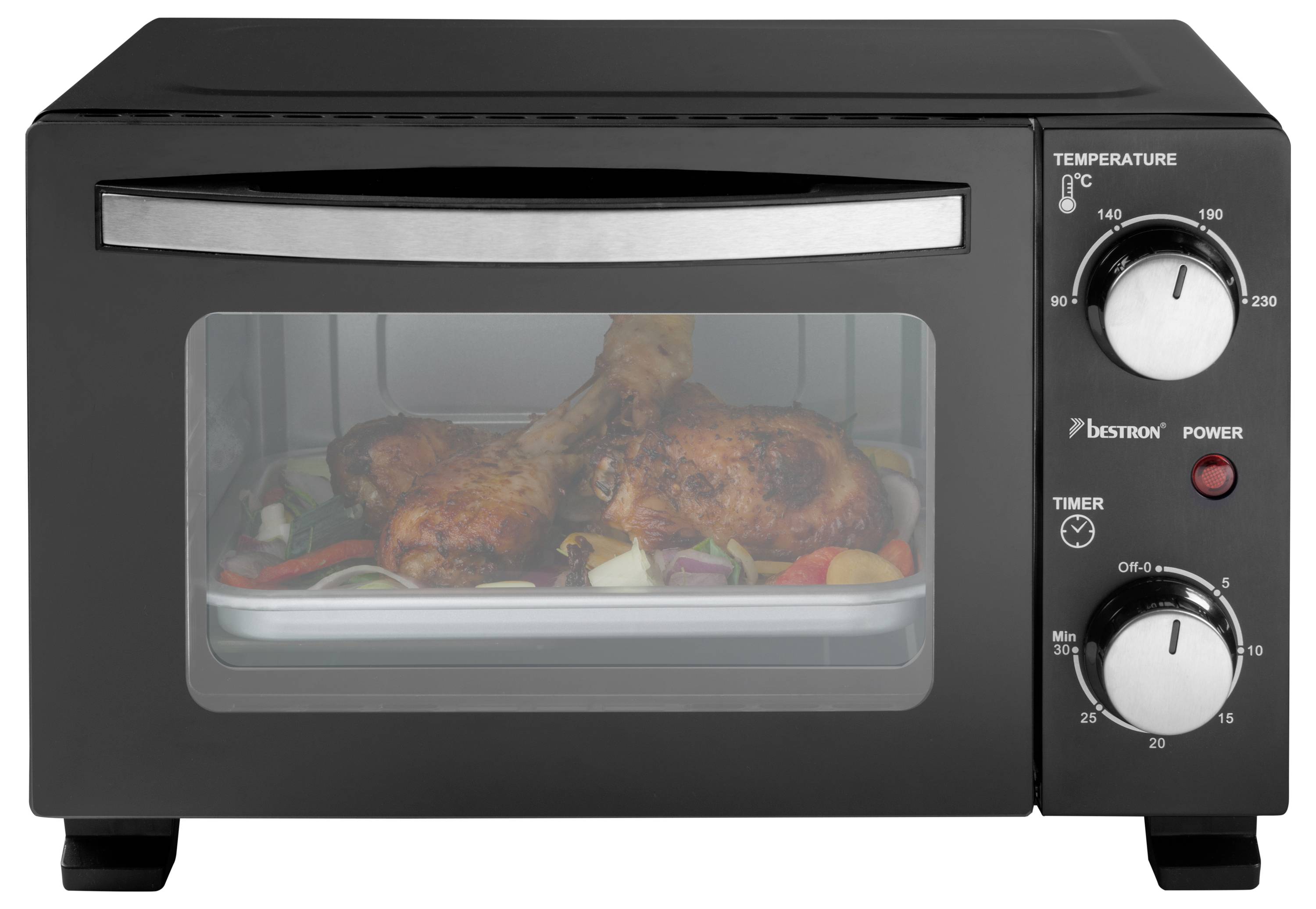 A compact black toaster oven with two control dials, showing roasted chicken legs and vegetables through the glass door.