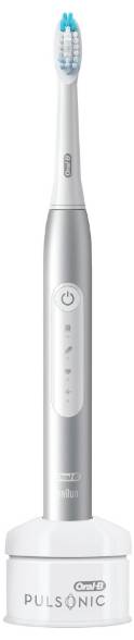 Electric toothbrush with a silver handle displaying power and mode buttons, standing in a charging base.