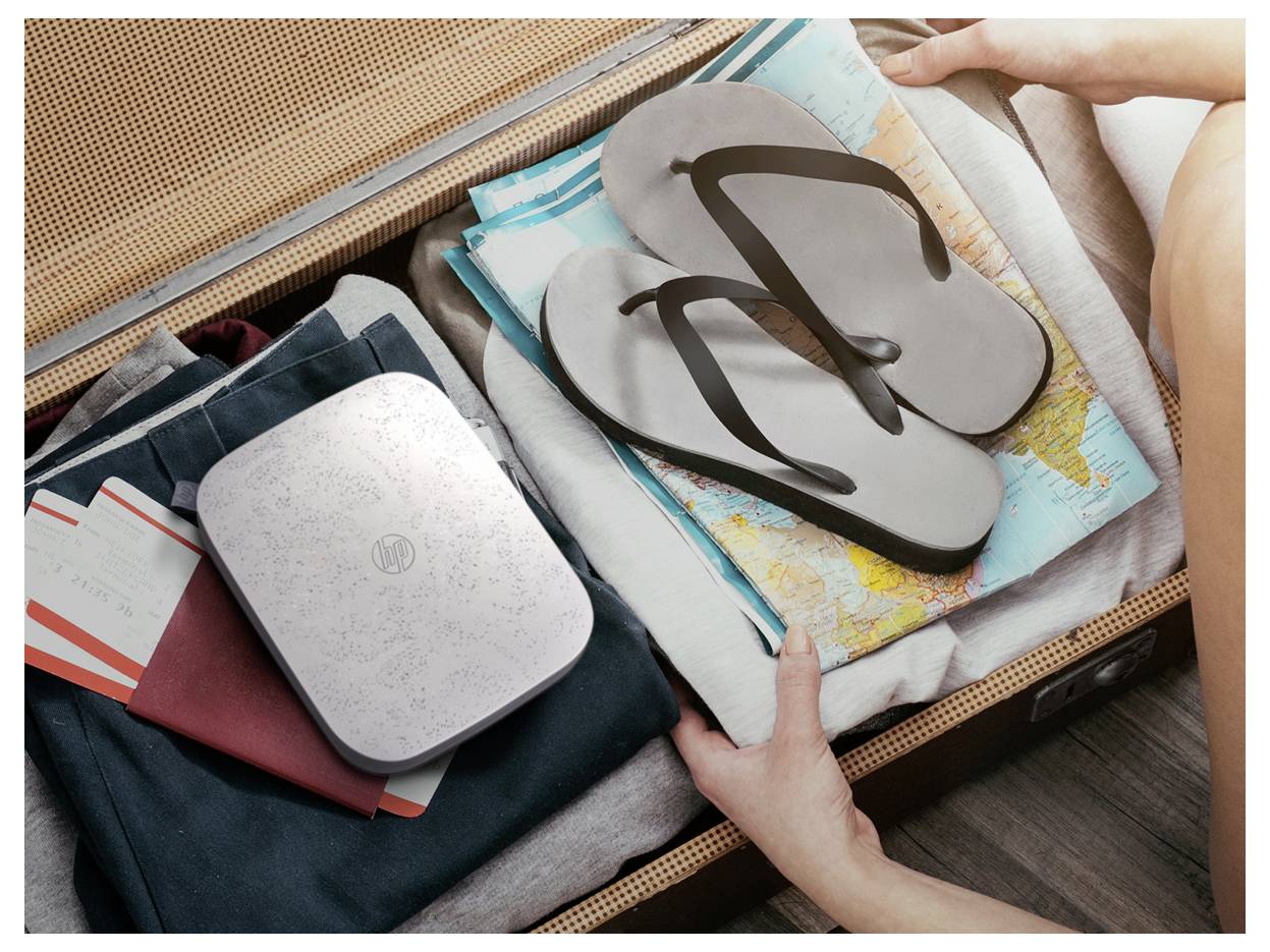 Hands packing a suitcase with folded clothes, flip-flops, and a map, suggesting travel preparation.