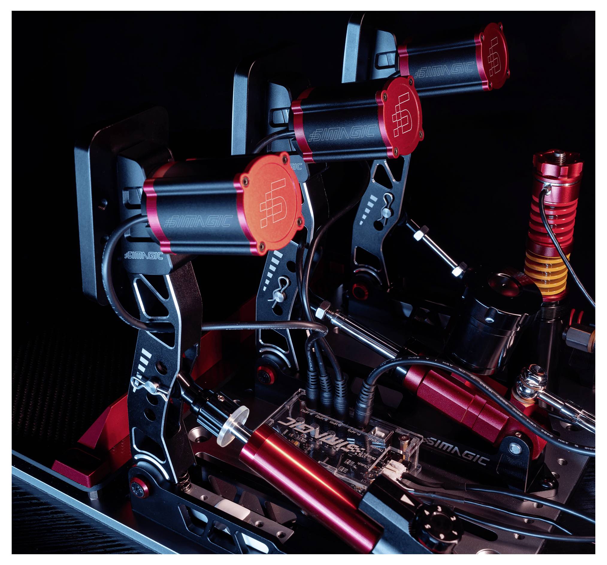 Three red and blue custom liquid-cooling pumps mounted on a PC motherboard, with tubing and fittings inside a computer case.