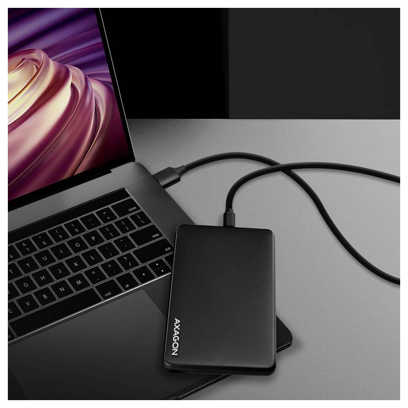 Laptop connected to an external Axagon drive via a USB cable on a desk.