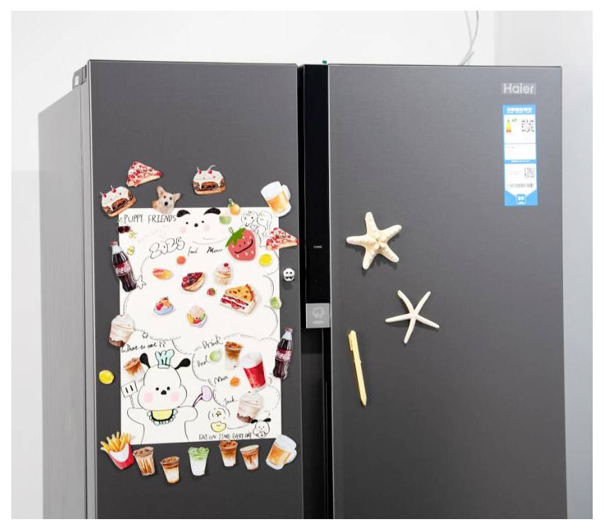 Two-door black Haier refrigerator with children’s drawings and dessert magnets on the left door, starfish and a stick-shaped magnet on the right.
