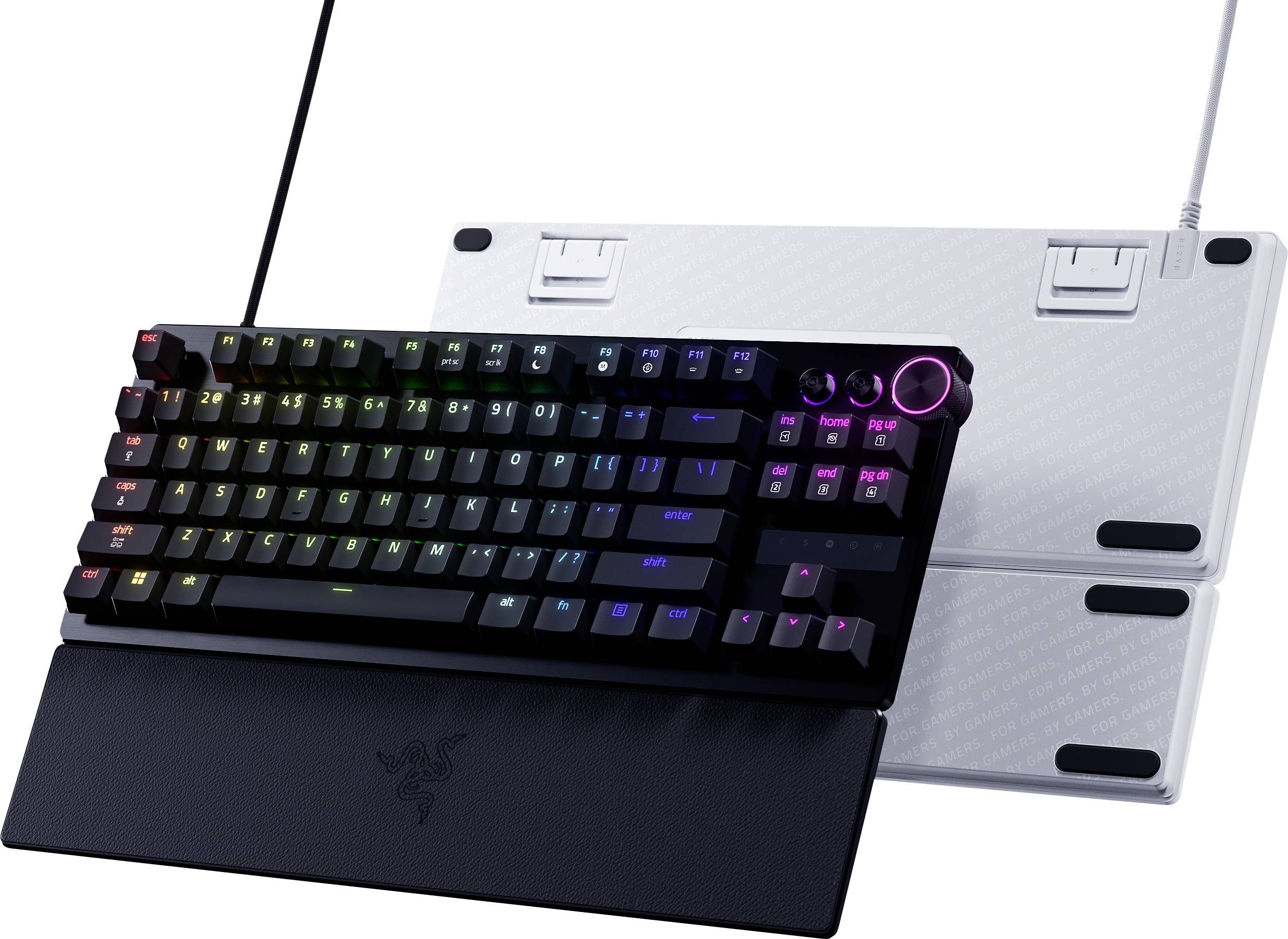 Mechanical gaming keyboard attached to a black laptop-style base, with rainbow backlit keys and a glowing pink control dial on a white stand behind it.