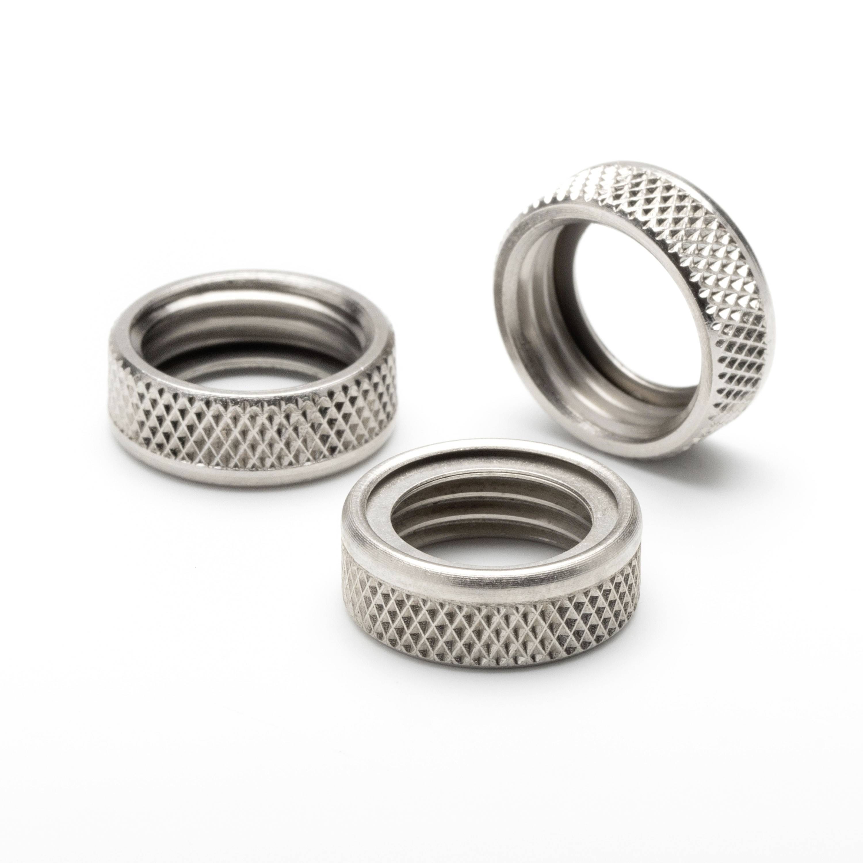 Three knurled metal threaded ring nuts on a white background, shown as small hardware parts.