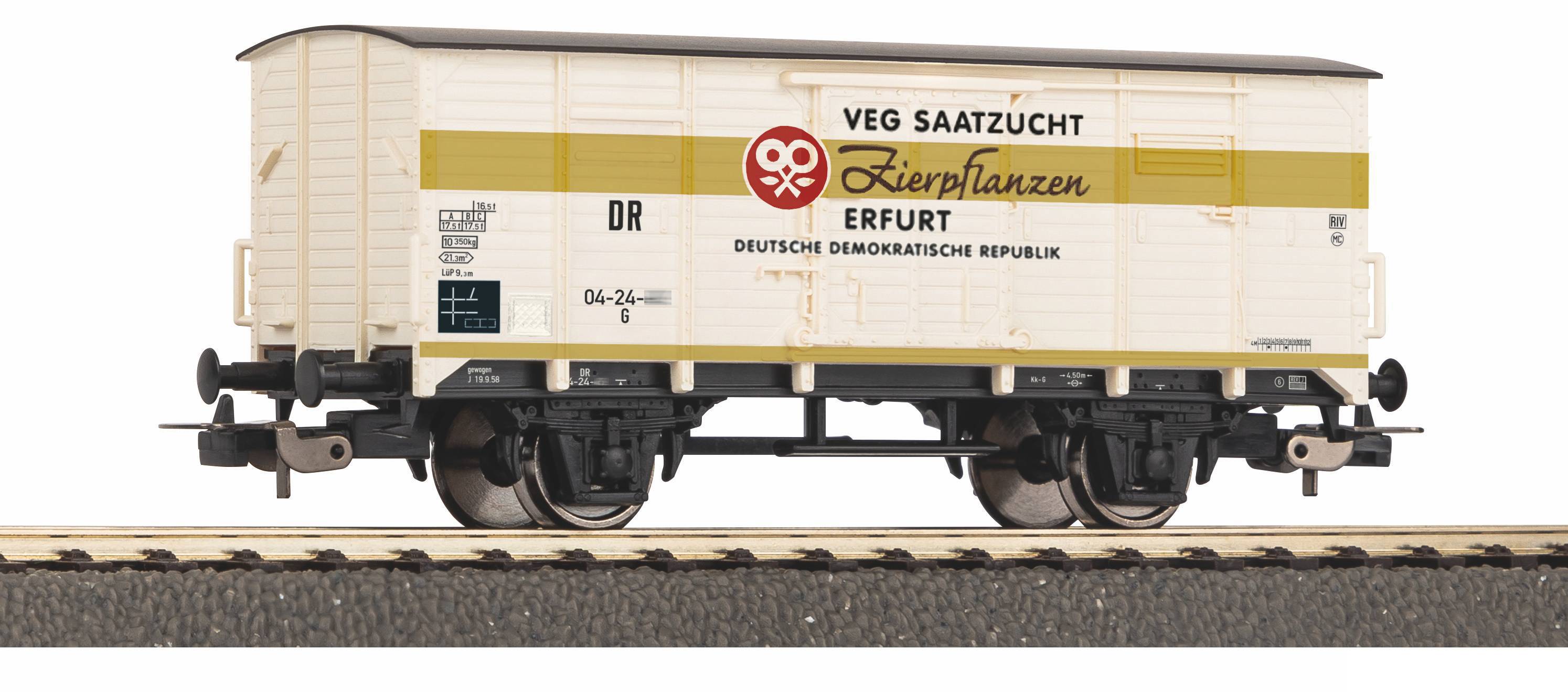Vintage white freight railcar model labeled 'VEG SAATZUCHT Zierpflanzen ERFURT' on a track, with black undercarriage and yellow stripe.