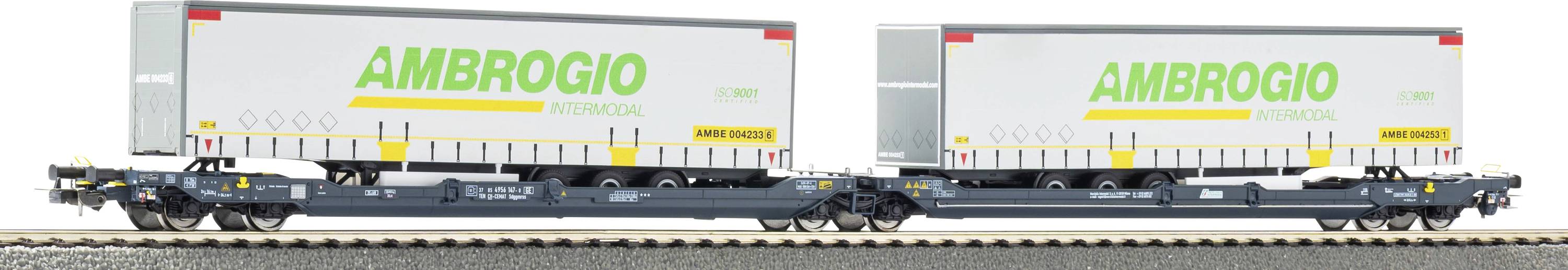 Two side-by-side Ambrogio Intermodal freight wagons carrying a white semi-trailer with green AMBROGIO logo.