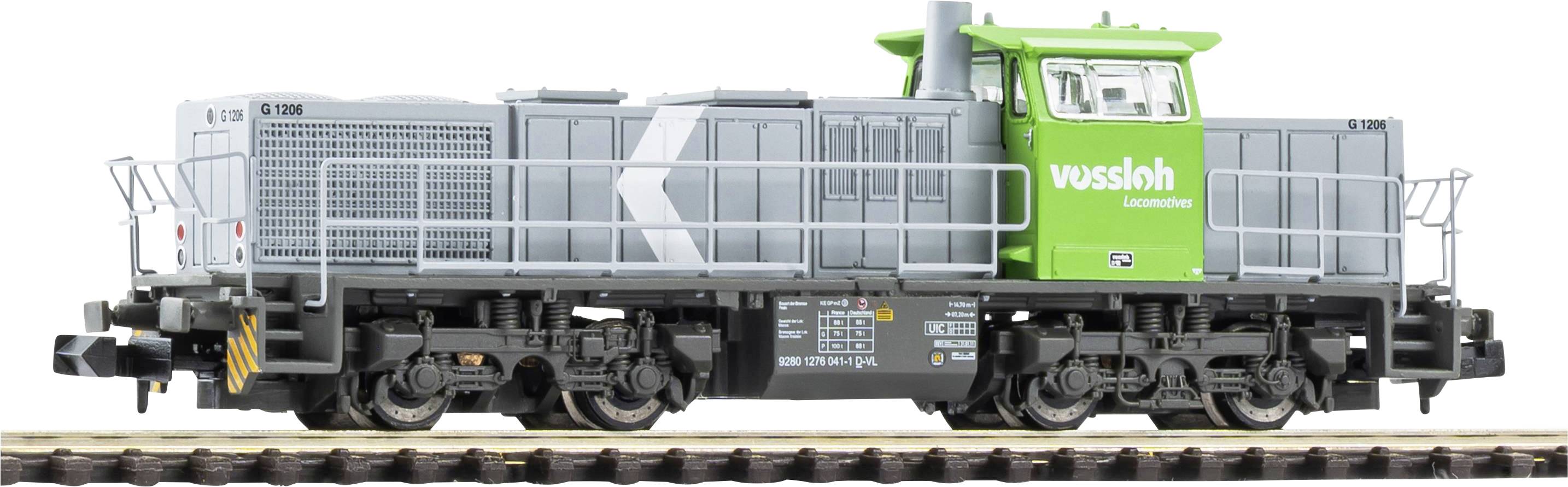 Green Vossloh rail maintenance locomotive with gray body and black undercarriage, shown in side view on tracks.