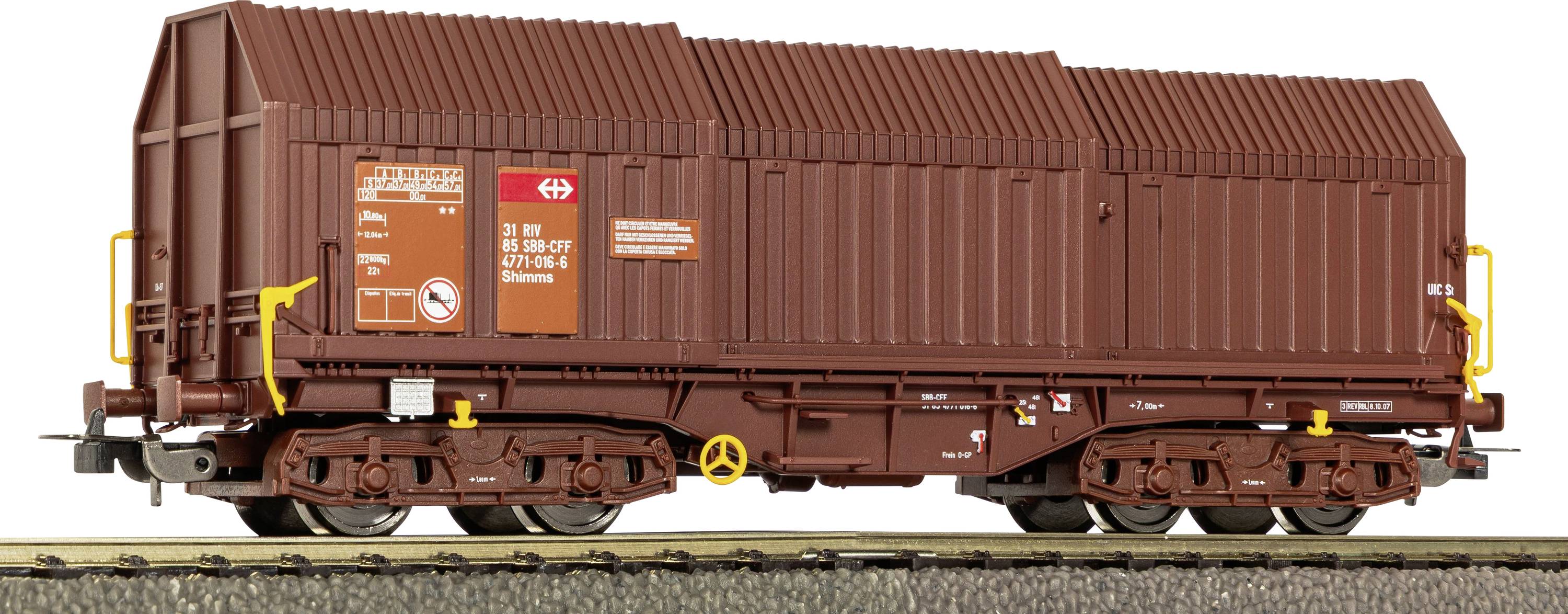 Brown covered freight railcar with orange warning labels and yellow handrails, shown in side view on tracks.
