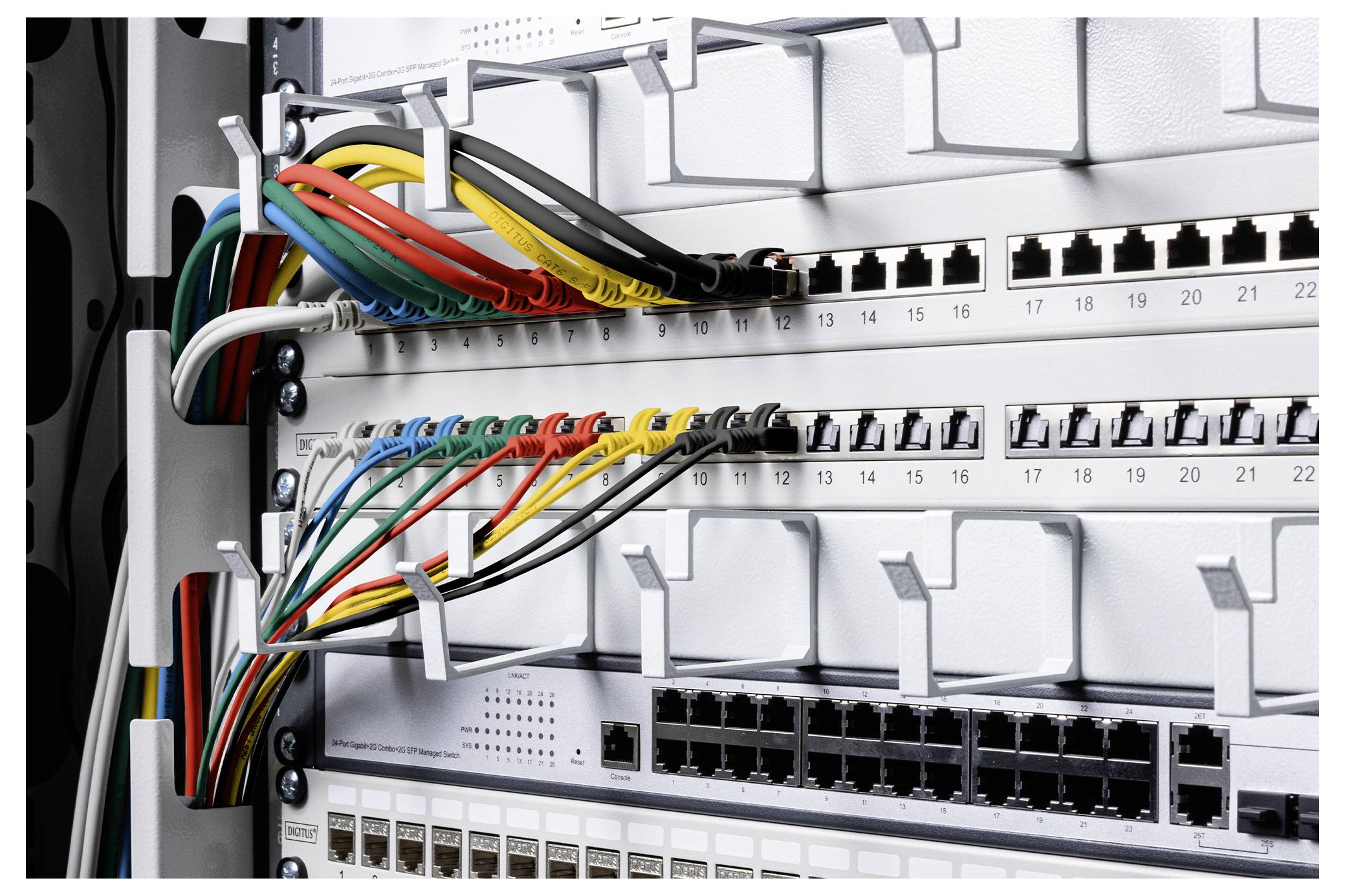 Close-up of a network switch patch panel with color-coded Ethernet cables connected to numbered ports in a server rack.