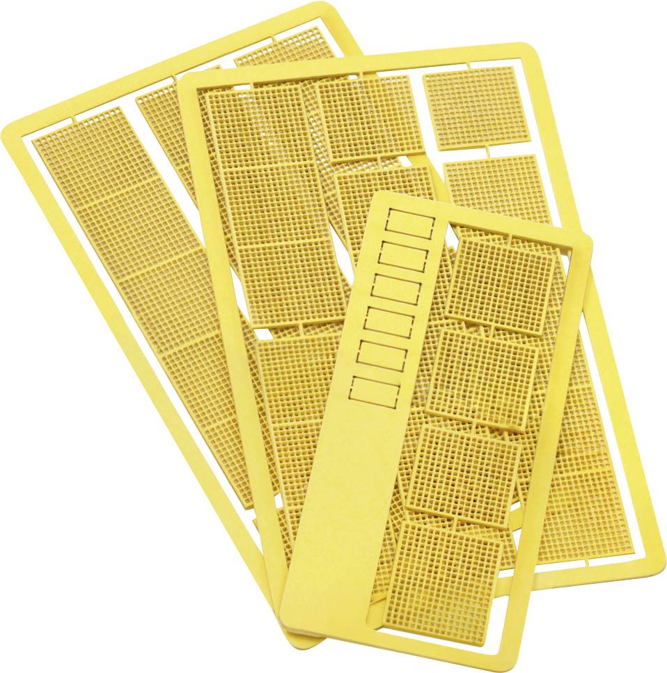 Stack of yellow plastic model airplane parts on a white background, including wing and fuselage frames with molded grid details.