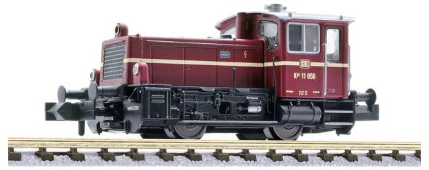 Side view of a red and black model railway locomotive on tracks, shown on a white background.