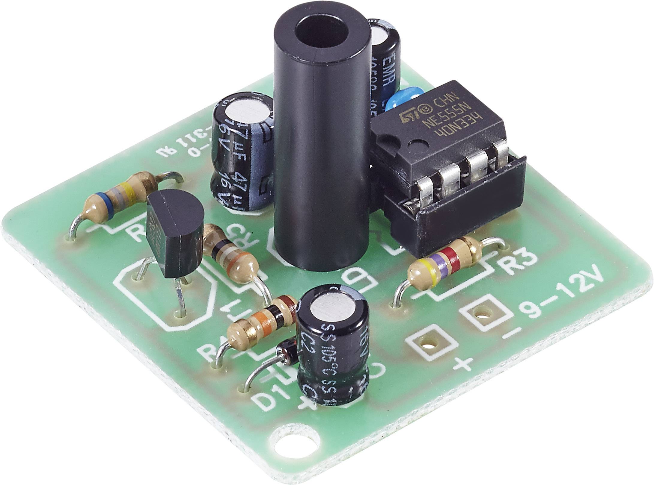 Green circuit board with various electronic components, including resistors, capacitors, and a black microchip.