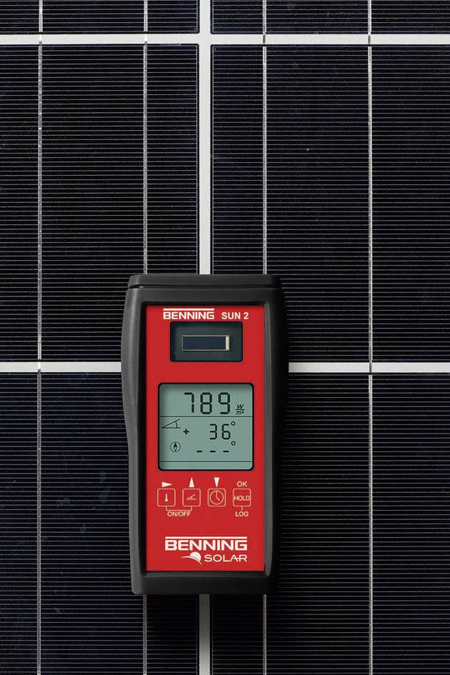 A digital solar measuring device displays '789' and '36°' on a screen, positioned in front of a solar cell.