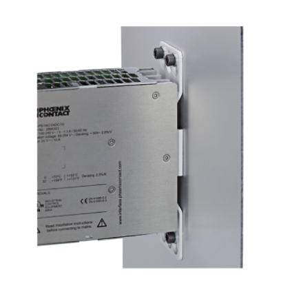 A metal device mounted with screws on a white wall. 'Phoenix Contact' lettering visible. Electronic component with ventilation slots.