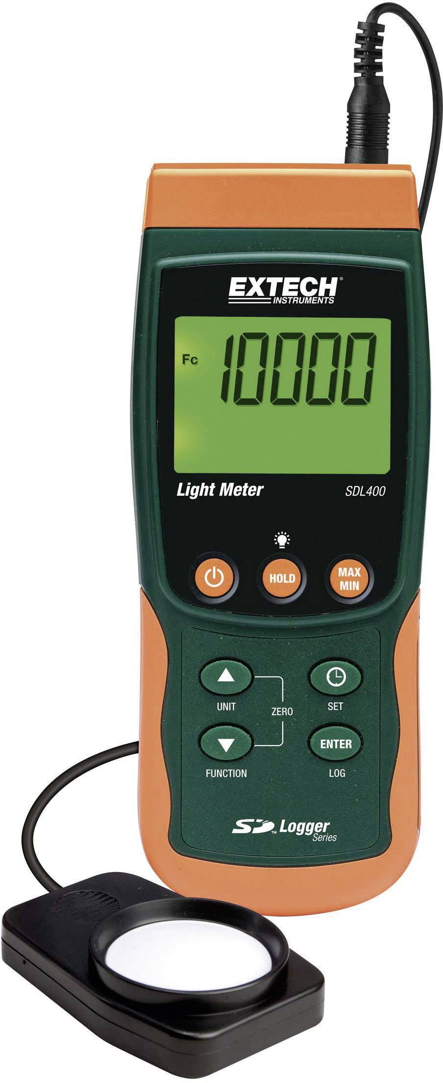A digital light metre with a large display shows a reading of '10,000'. The device has an orange-green casing with buttons and an external sensor.