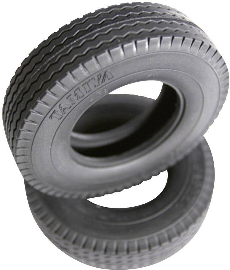Two stacked toy tyres made of black rubber with a ribbed tread are positioned at an angle to each other.