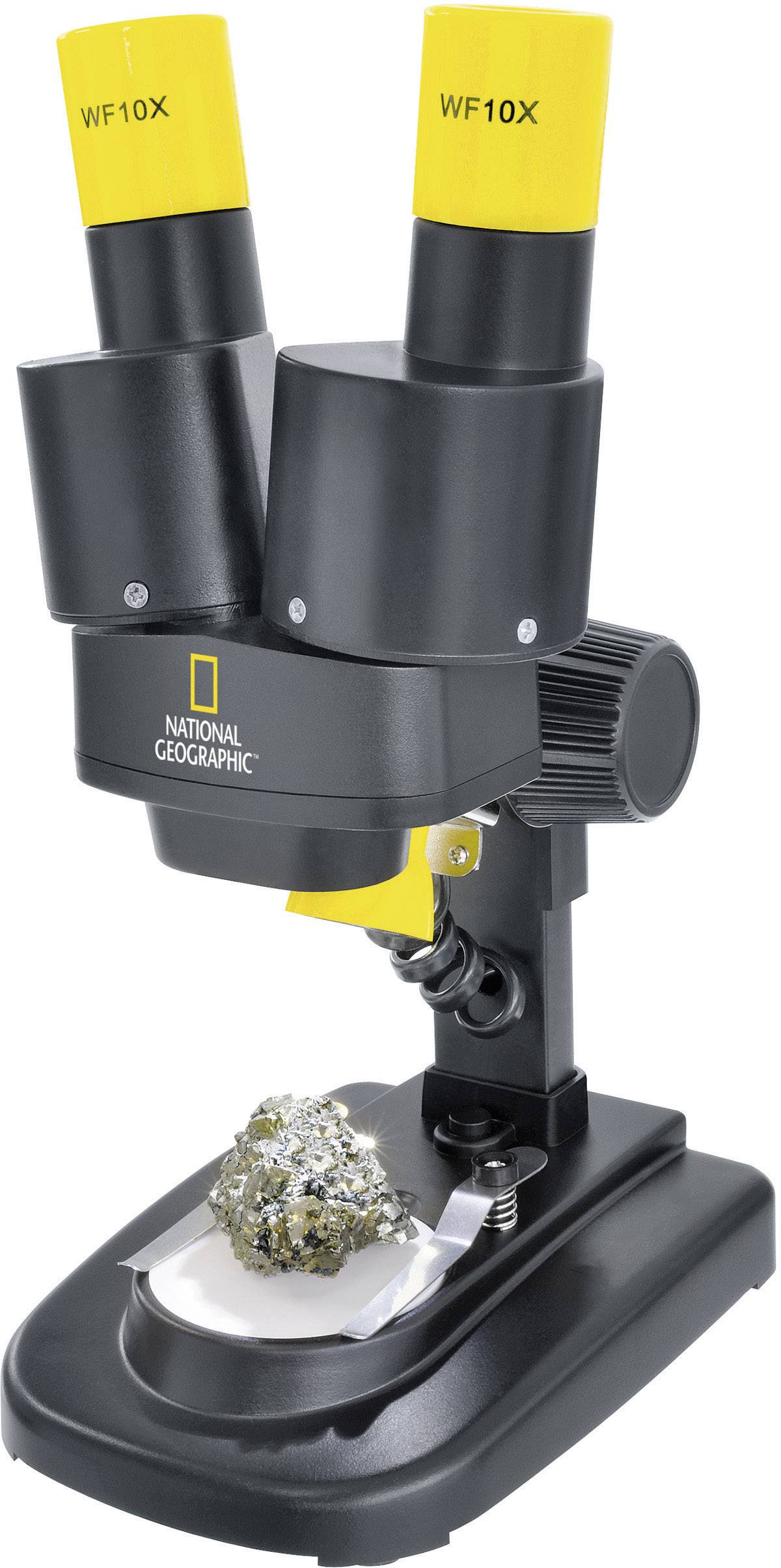 Microscope with twin eyepieces and an illuminated rock specimen on the platform. Marked with 'National Geographic'.